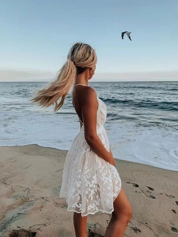 Robe blanche sexy à bretelles spaghetti pour femme, tenue d'été brodée en maille et dentelle, dos nu, idéale pour la plage ou les loisirs.